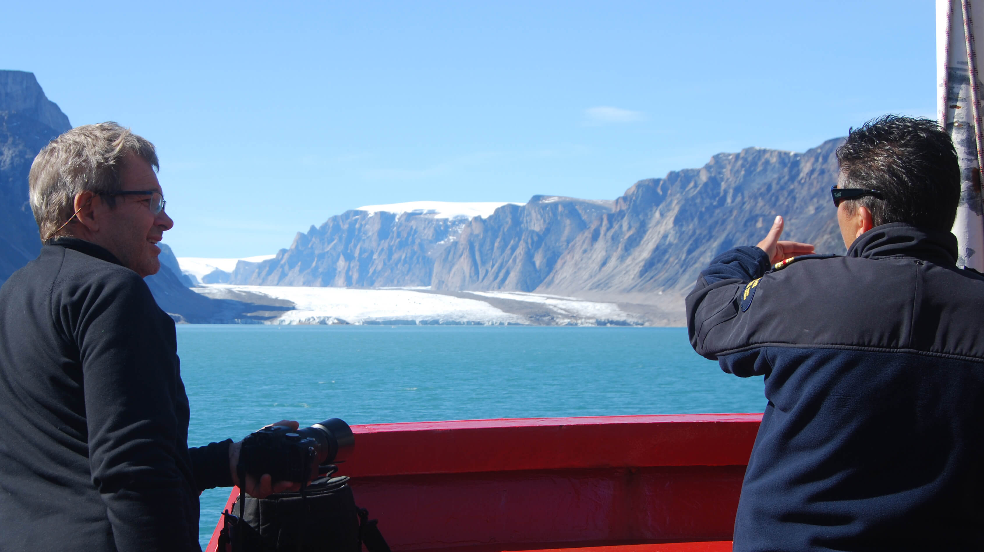 Mentor Marc Picheral discussing glacier features with a coast guard officer  - Sentinel North international phd school